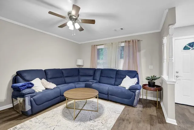 a living room with furniture and a ceiling fan