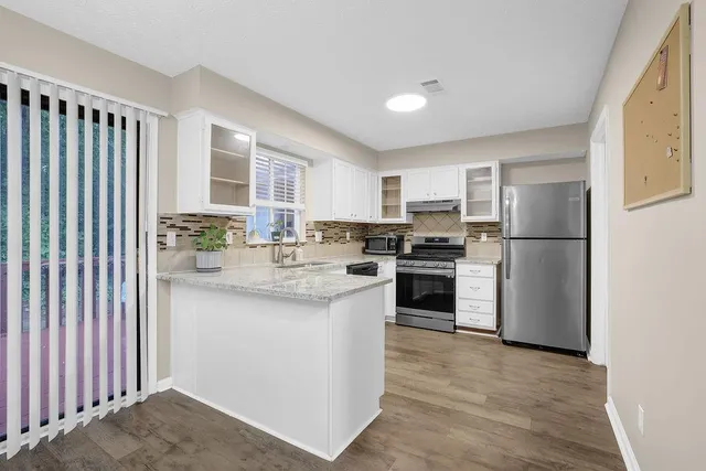 a kitchen with stainless steel appliances granite countertop a refrigerator sink and stove