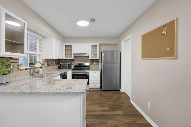 a kitchen with granite countertop a refrigerator and a sink