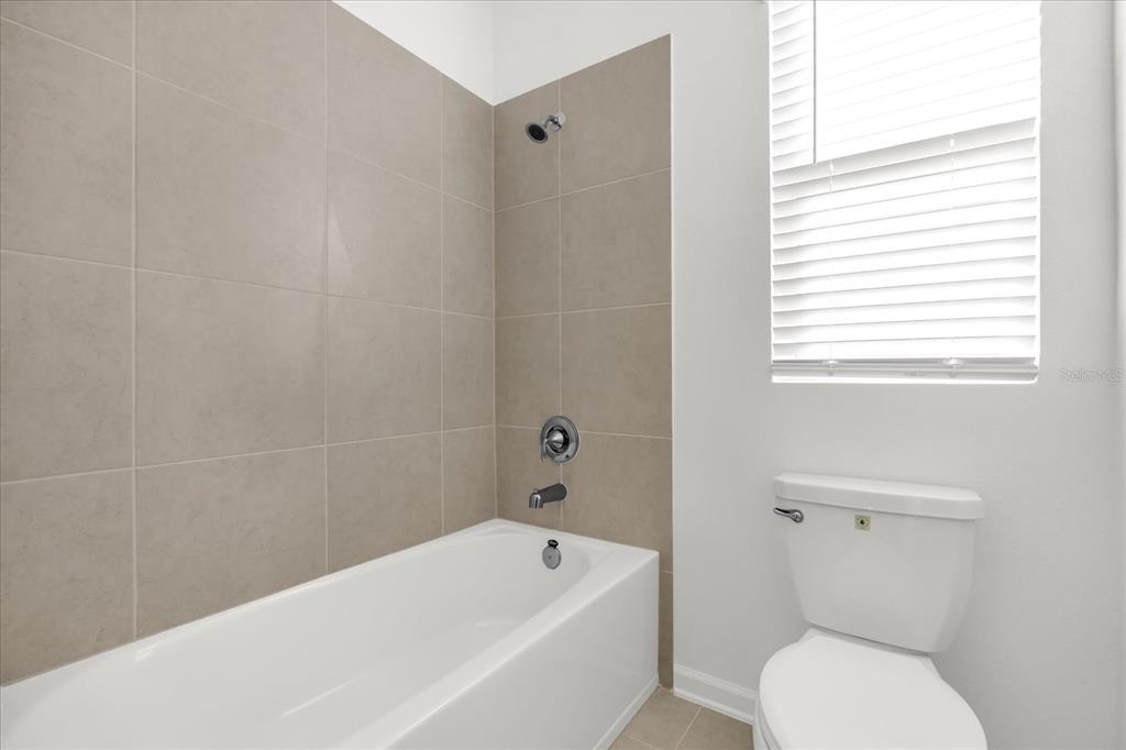 2911 Transformation Way Clermont, FL 34714 - Photo 16 of 27 a bathroom with a toilet and bathtub