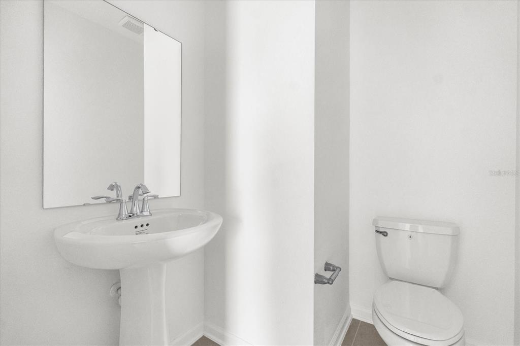 2911 Transformation Way Clermont, FL 34714 - Photo 19 of 27 a bathroom with a toilet sink and mirror