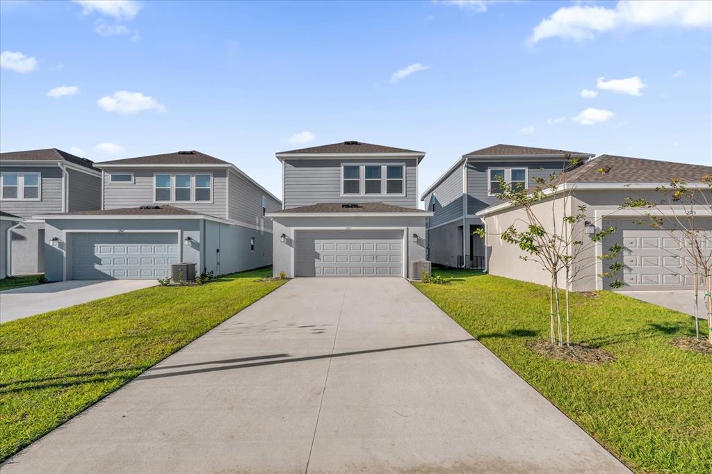 2911 Transformation Way Clermont, FL 34714 - Photo 22 of 27 a front view of a house with a yard and garage