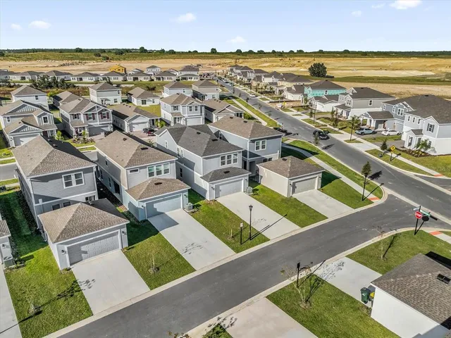 an aerial view of residential houses with outdoor space and ocean view