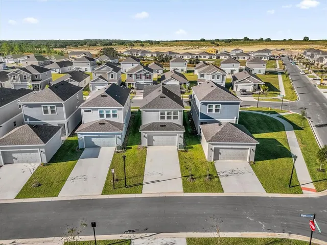 an aerial view of residential houses with outdoor space and ocean view