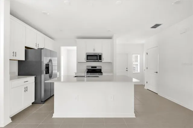 a large kitchen with cabinets and stainless steel appliances