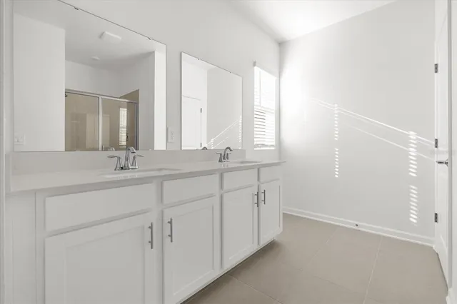 a bathroom with double sink and a mirror