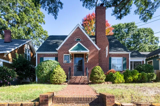 front view of house with a yard and potted plants