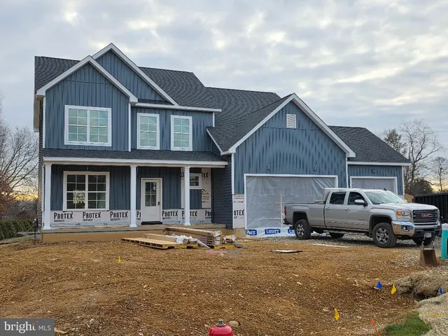 a front view of a house with cars parked