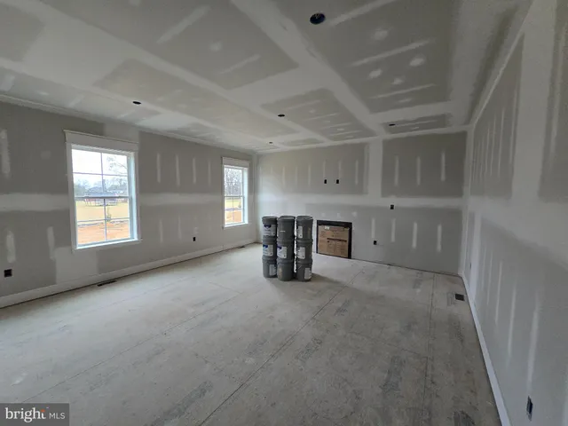 an empty room with fireplace and windows