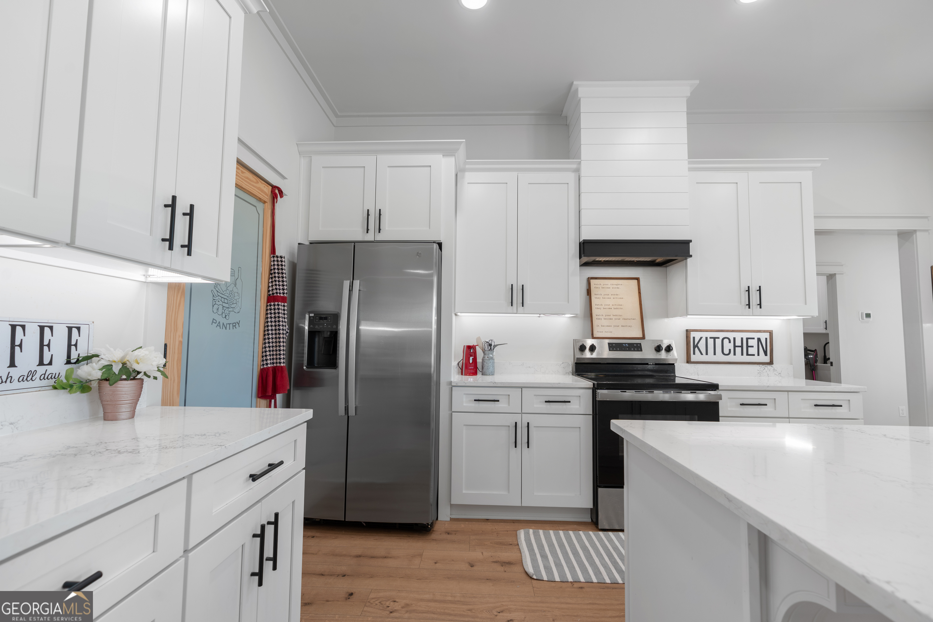 4005 Golfview Drive Blackshear, GA 31516 - Photo 9 of 40 a kitchen with a sink dishwasher a refrigerator a stove and white cabinets with wooden floor
