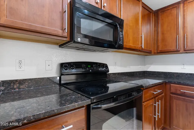 a kitchen with stainless steel appliances granite countertop a refrigerator and a stove top oven