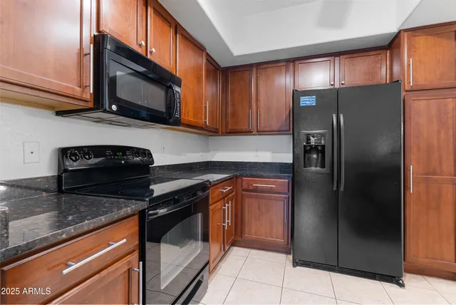 a kitchen with stainless steel appliances granite countertop a refrigerator and a stove top oven