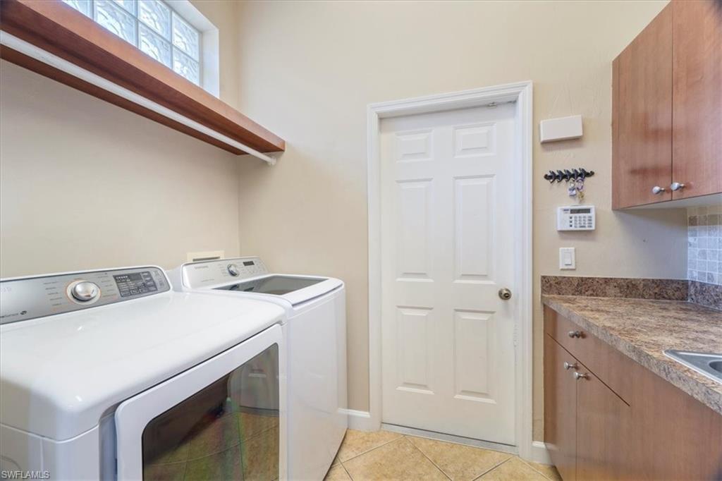 3343 Sandpiper Way Naples, FL 34109 - Photo 16 of 31 Clothes washing area with cabinets, light tile patterned floors, and washer and clothes dryer