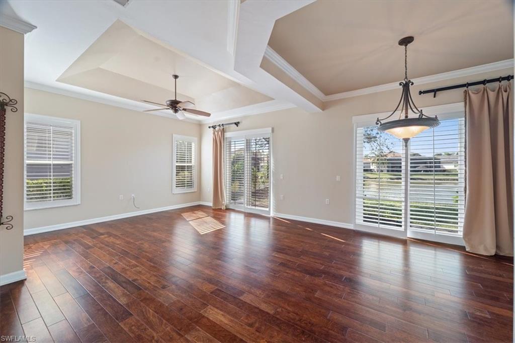 3343 Sandpiper Way Naples, FL 34109 - Photo 6 of 31 Spare room with ceiling fan, a healthy amount of sunlight, dark wood-type flooring, and a tray ceiling