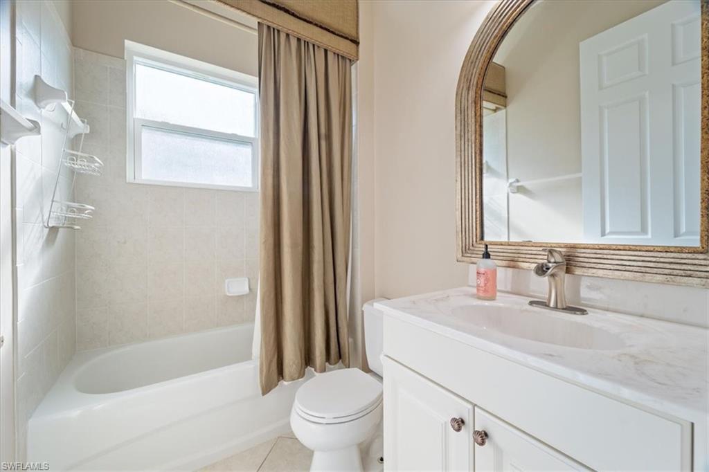 3343 Sandpiper Way Naples, FL 34109 - Photo 7 of 31 Full bathroom featuring tile patterned floors, vanity, shower / tub combo, and toilet