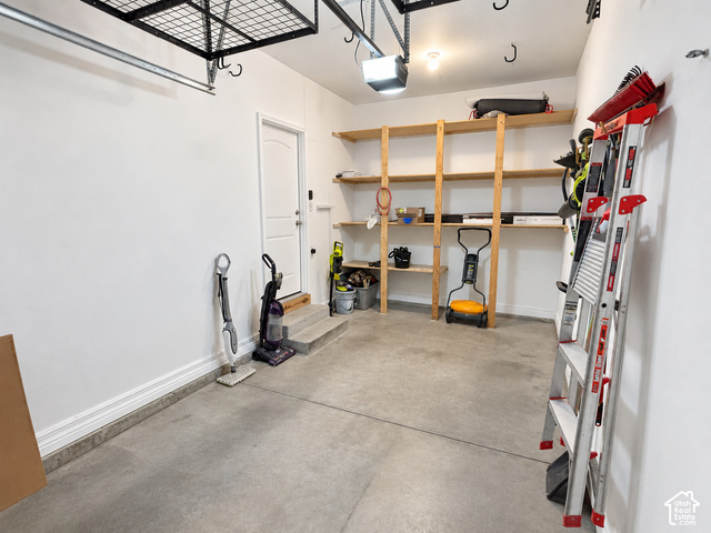 11689 South Shadow View Lane Draper, UT 84020 - Photo 23 of 25 Attached overhead storage rack, concrete flooring, built-in wooden shelving, and a white access door