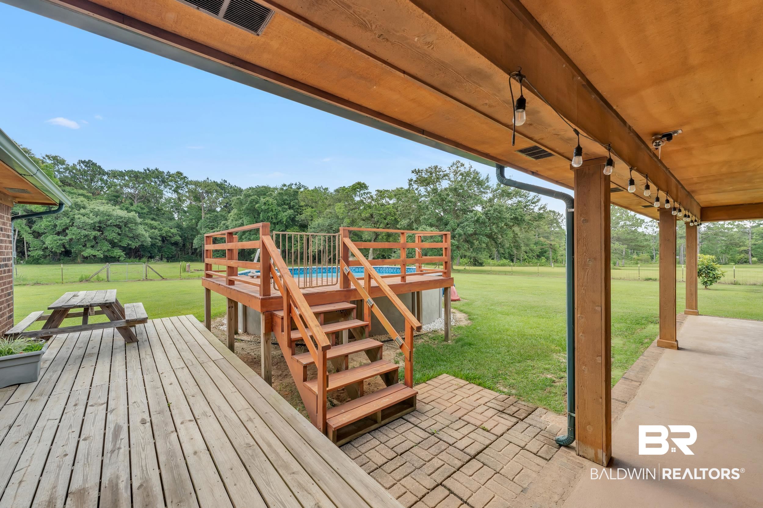 4062 River Road Theodore, AL 36582 - Photo 16 of 32 Deck with a patio area, view of scattered trees, and stairs