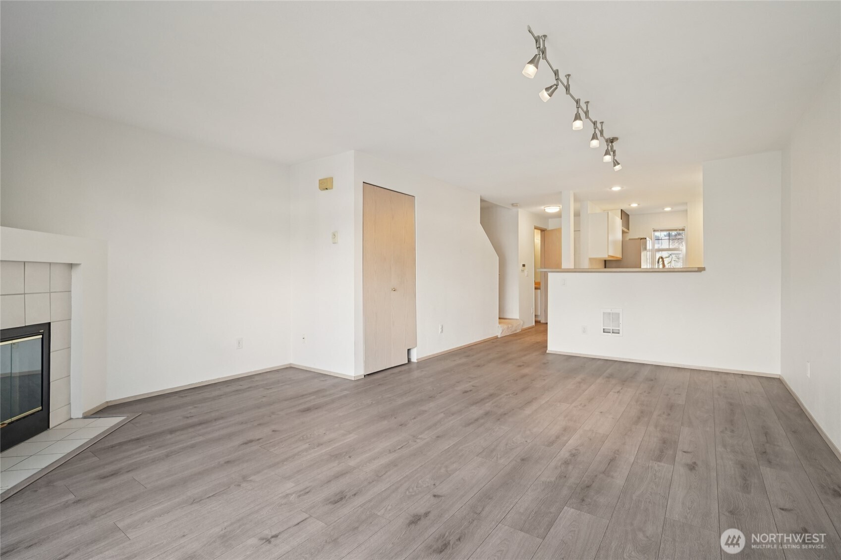 23628 55th Place South, Unit 153 Kent, WA 98032 - Photo 5 of 28 an empty room with wooden floor and a kitchen