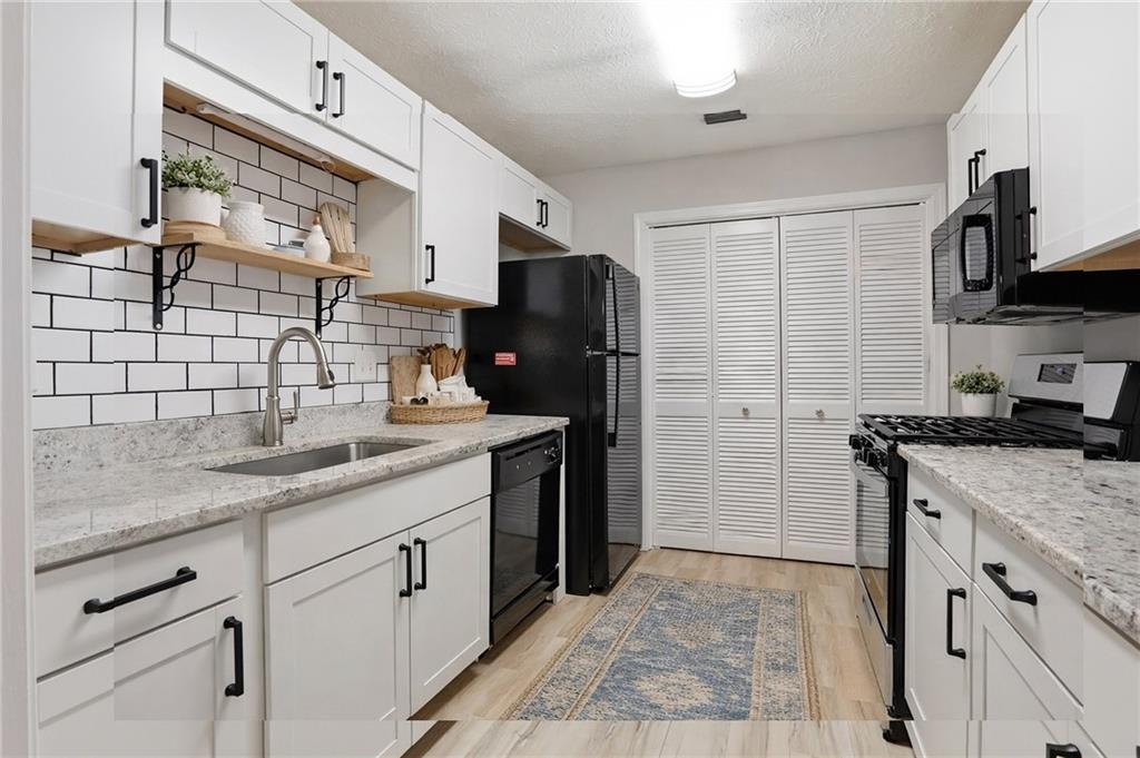106 Berkeley Woods Drive Duluth, GA 30096 - Photo 6 of 17 a kitchen with stainless steel appliances granite countertop a sink stove and refrigerator