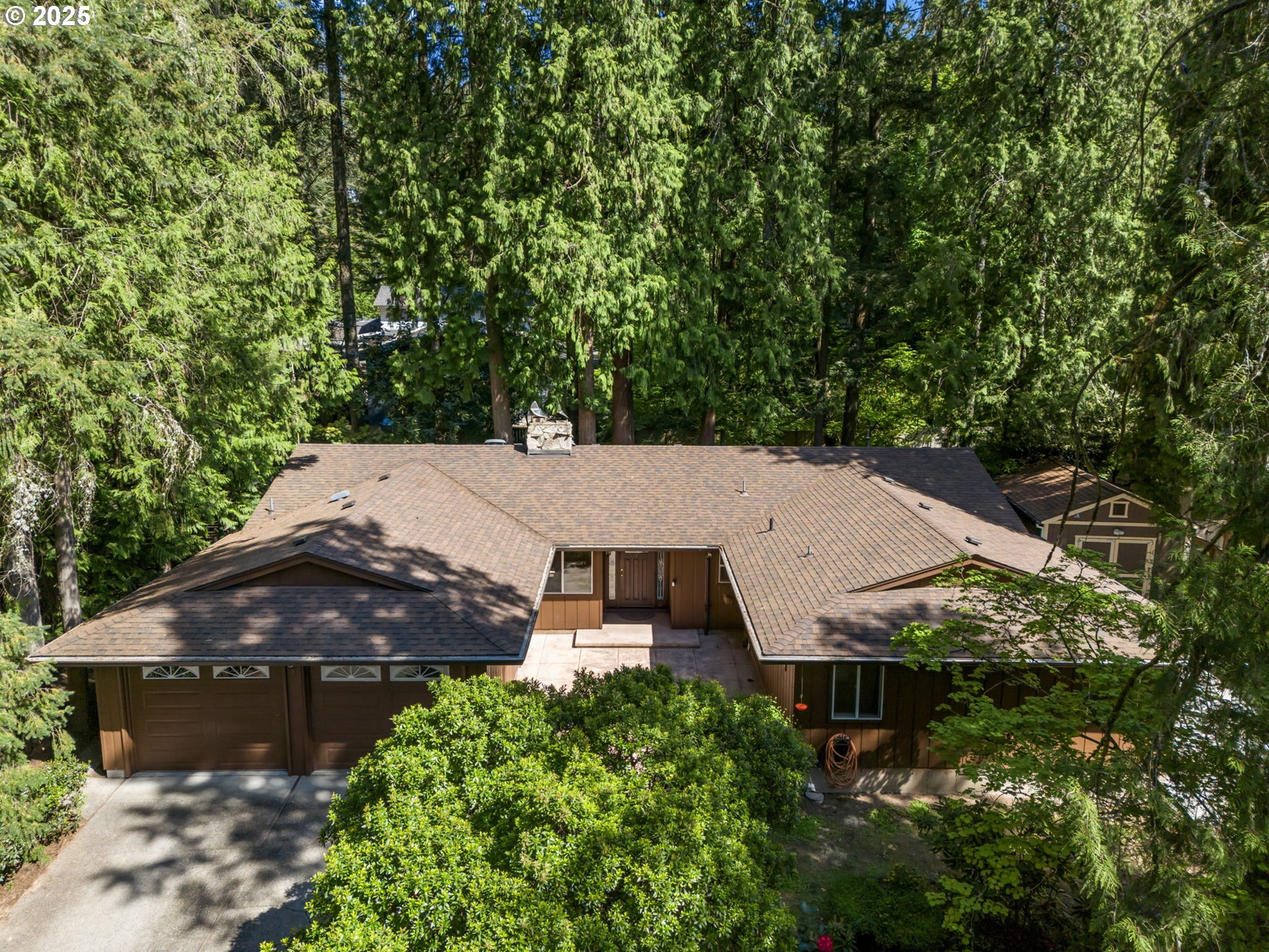 an aerial view of a house with yard and large tree