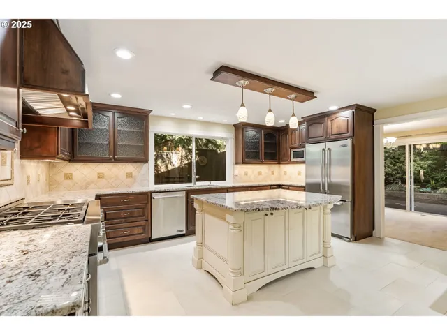 a kitchen with stainless steel appliances kitchen island granite countertop a stove and a sink