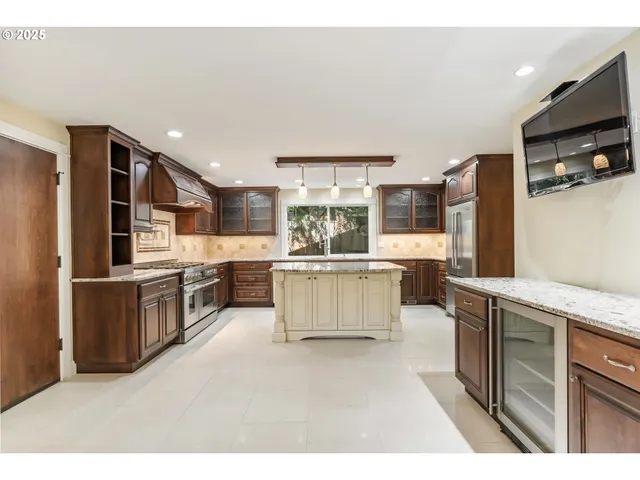 a large kitchen with stainless steel appliances kitchen island granite countertop a large counter top and oven