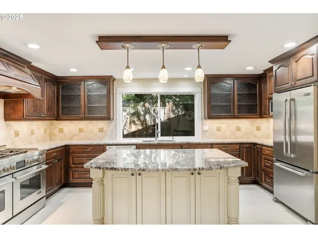 a kitchen with stainless steel appliances granite countertop a sink stove and refrigerator