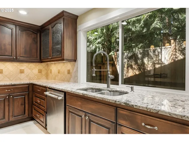 a kitchen with granite countertop sink and cabinets