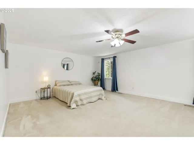 a bedroom with a bed and a ceiling fan