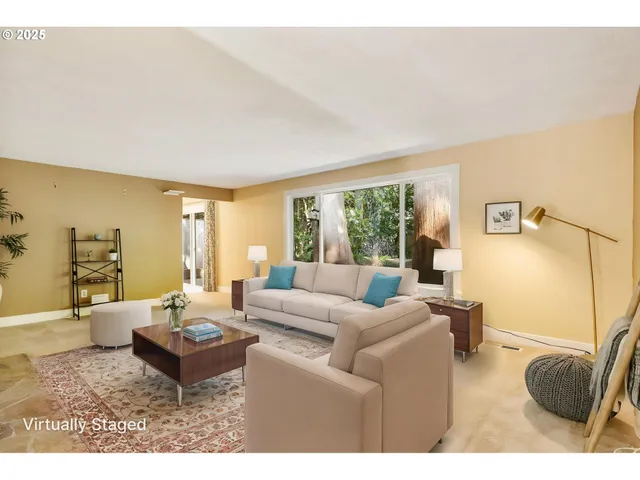 a living room with furniture a rug potted plant and a large window
