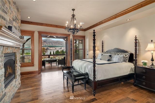 a bedroom with a large bed a flat tv screen and a fireplace