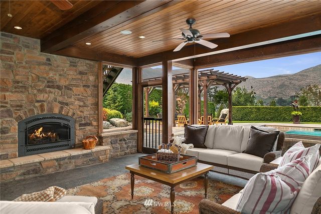 a living room with furniture a fireplace and a floor to ceiling window
