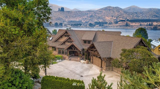an aerial view of a house with a yard and a large tree
