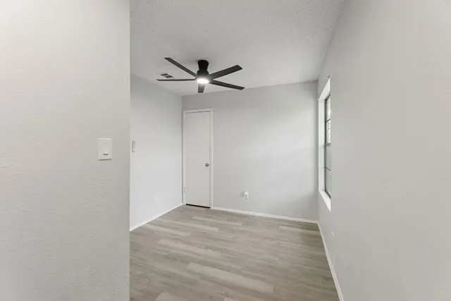 a view of a big room with wooden floor and a ceiling fan