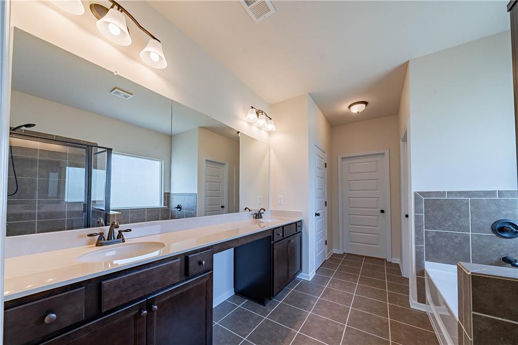 10 Edgewater Court Covington, GA 30016 - Photo 13 of 25 a bathroom with a double vanity sink a mirror and a shower