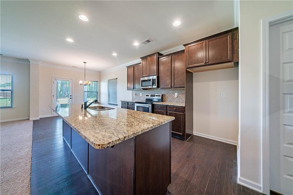 10 Edgewater Court Covington, GA 30016 - Photo 3 of 25 a kitchen with stainless steel appliances granite countertop a refrigerator a sink dishwasher and a stove with wooden floor