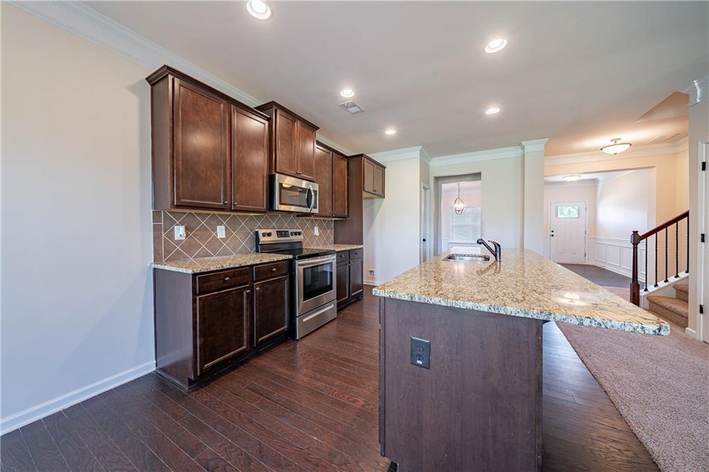 10 Edgewater Court Covington, GA 30016 - Photo 4 of 25 a kitchen with stainless steel appliances granite countertop a stove a sink and a refrigerator