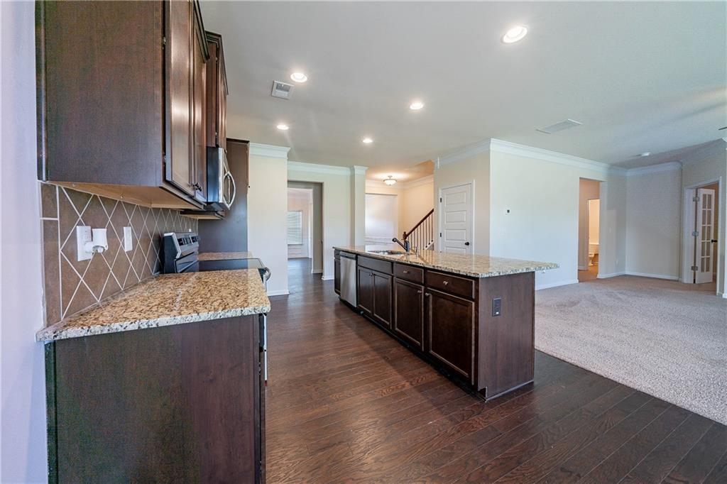 10 Edgewater Court Covington, GA 30016 - Photo 5 of 25 a large kitchen with stainless steel appliances kitchen island granite countertop a large counter top and wooden floor