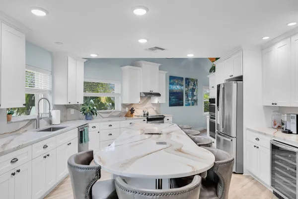 a kitchen with stainless steel appliances kitchen island granite countertop a sink cabinets and wooden floor