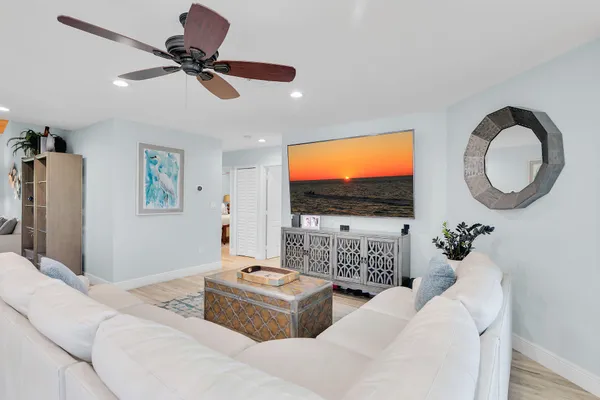 a living room with furniture a flat screen tv and a floor to ceiling window