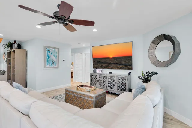 a living room with furniture a flat screen tv and a floor to ceiling window