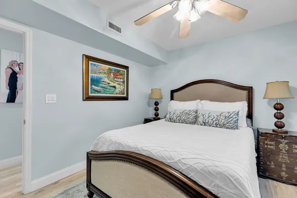 a bedroom with a bed and a painting on the wall