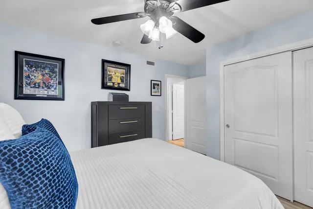 a bedroom with a large bed and a ceiling fan