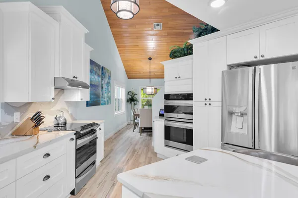 a kitchen with stainless steel appliances granite countertop a stove a sink a microwave a dining table and chairs