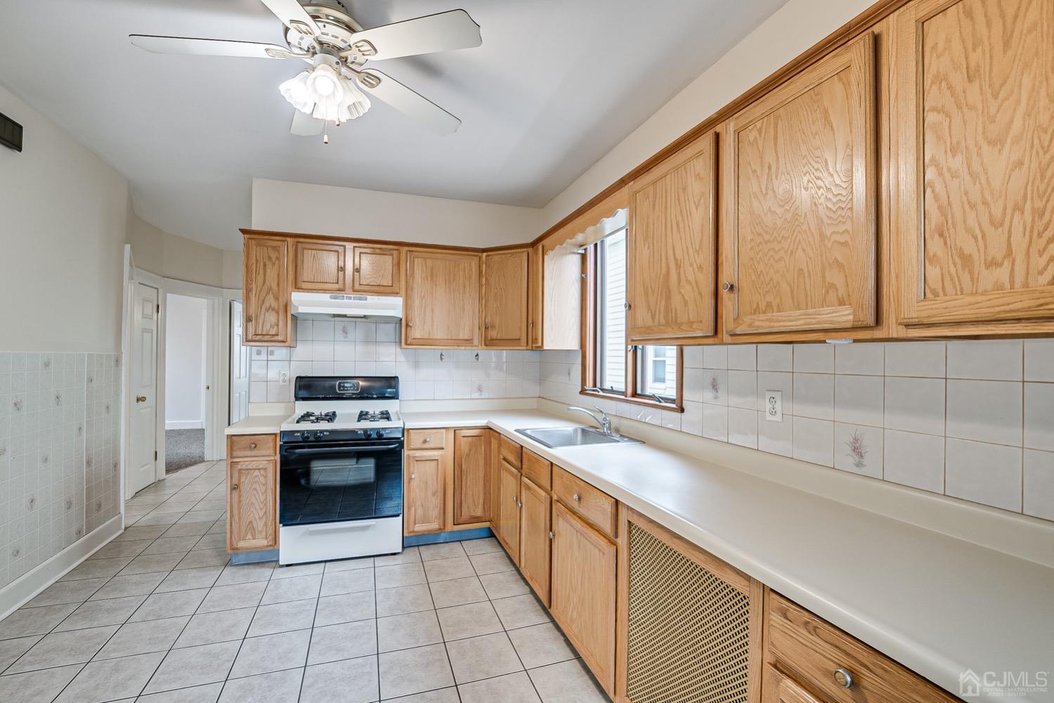906-908 Kilsyth Road Elizabeth, NJ 07208 - Photo 10 of 50 a kitchen with stainless steel appliances granite countertop a sink a stove cabinets and entryway