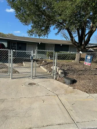 a view of a house with a backyard and a tree