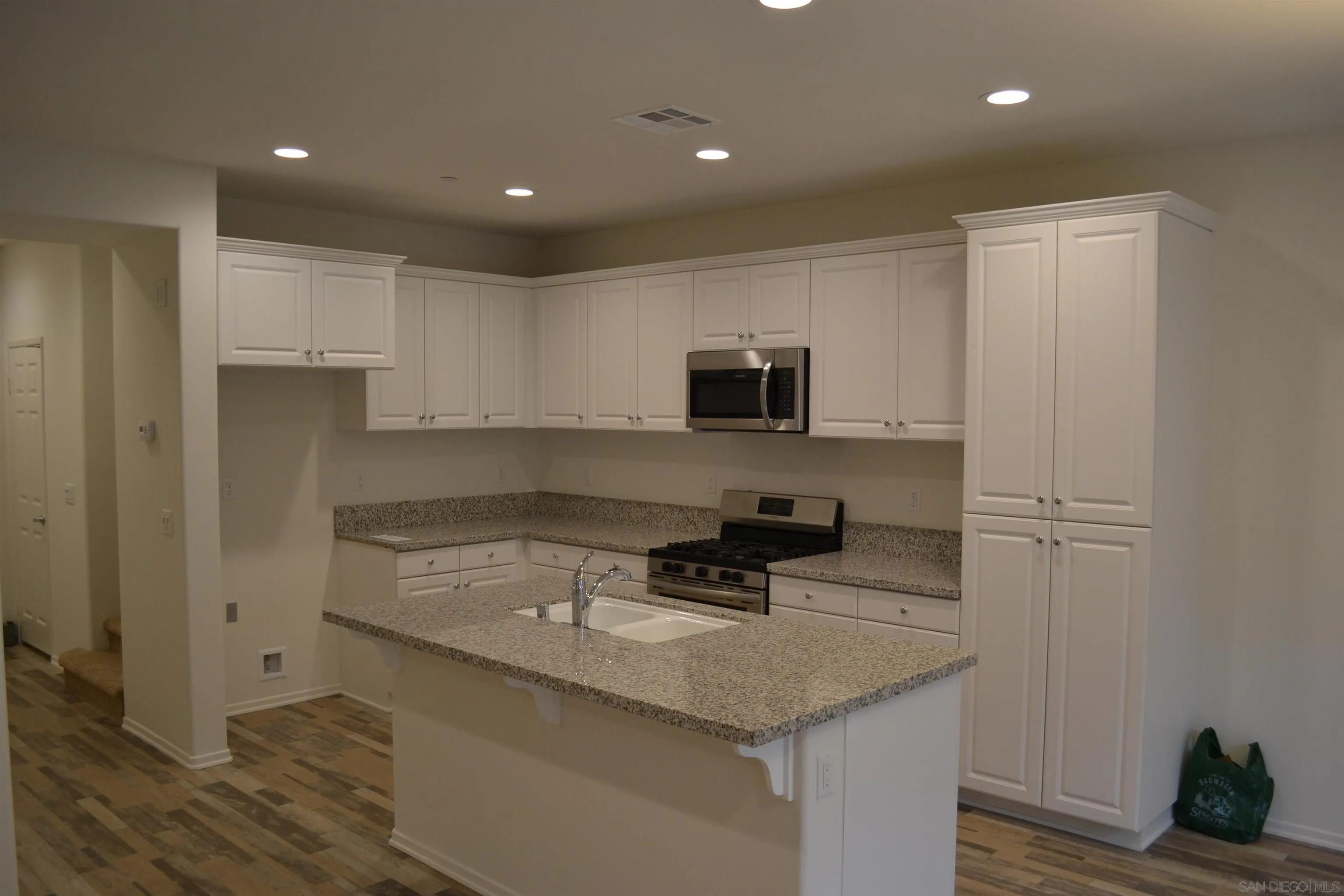 35329 White Camarillo Lane Fallbrook, CA 92028 - Photo 4 of 16 a kitchen with a sink a stove a microwave and cabinets