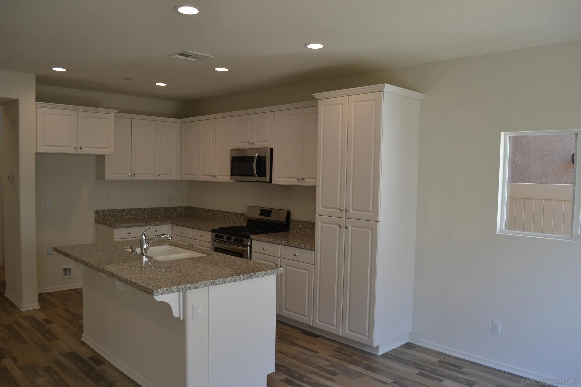 35329 White Camarillo Lane Fallbrook, CA 92028 - Photo 6 of 16 a kitchen that has a sink a microwave a refrigerator and cabinets