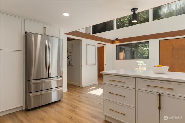 a kitchen with stainless steel appliances a refrigerator and wooden floor
