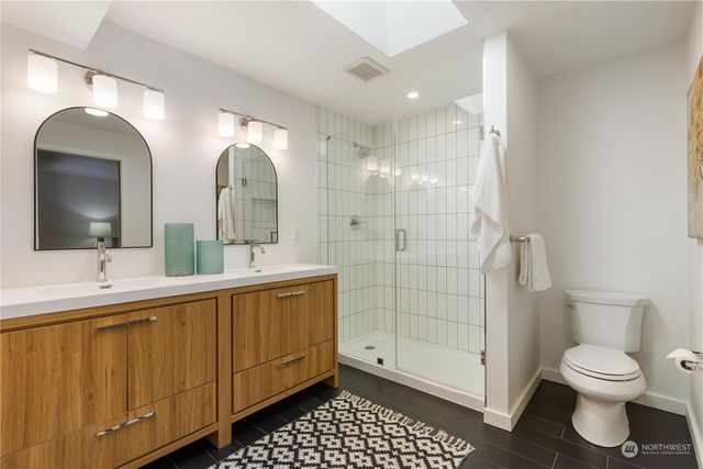 a bathroom with a double vanity sink toilet and shower